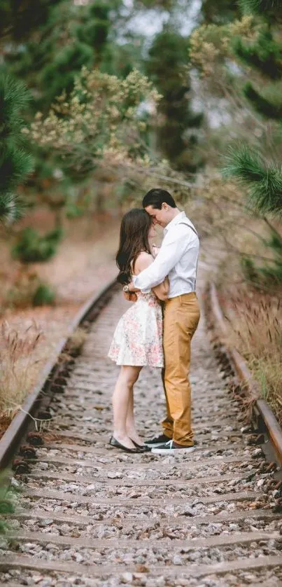 Couple embracing on a railway track with green nature.