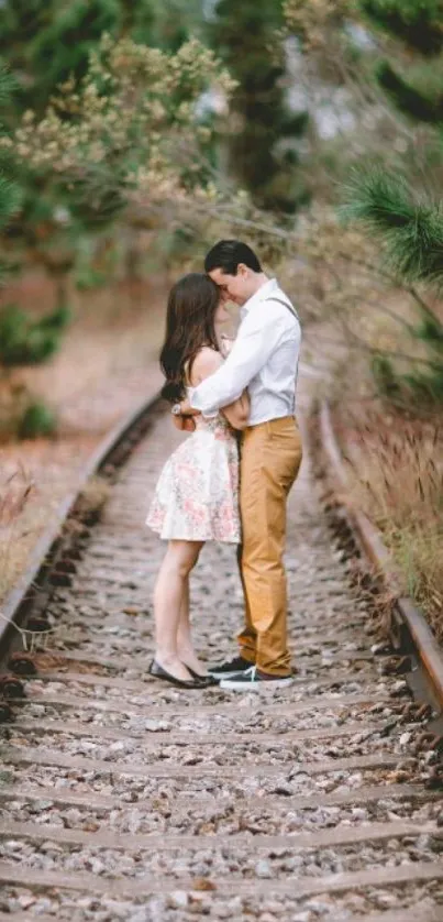 Couple embracing on a forest railway track.