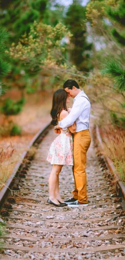 Romantic couple embraces on a railway path in nature.