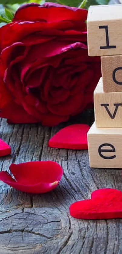Wooden background with red rose and love blocks.