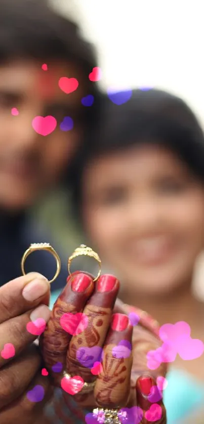 Couple holding engagement rings, blurred background.