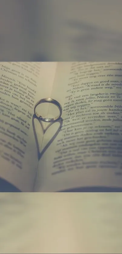 Ring creates heart shadow on book pages, romantic mobile wallpaper.