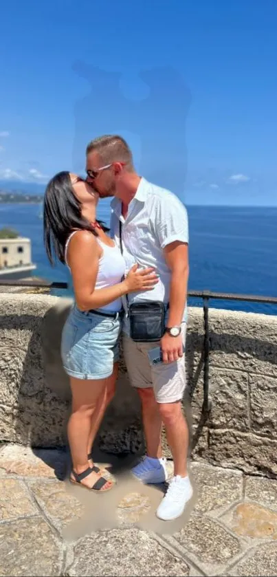 Couple kissing by the seaside with clear blue skies.