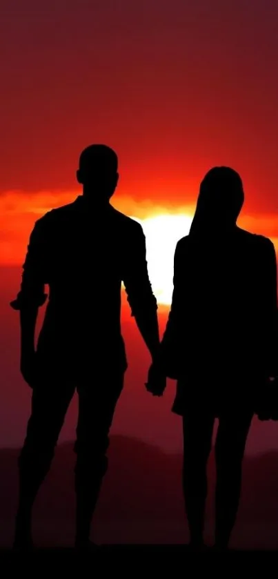 Silhouette of a couple against a vivid red sunset.