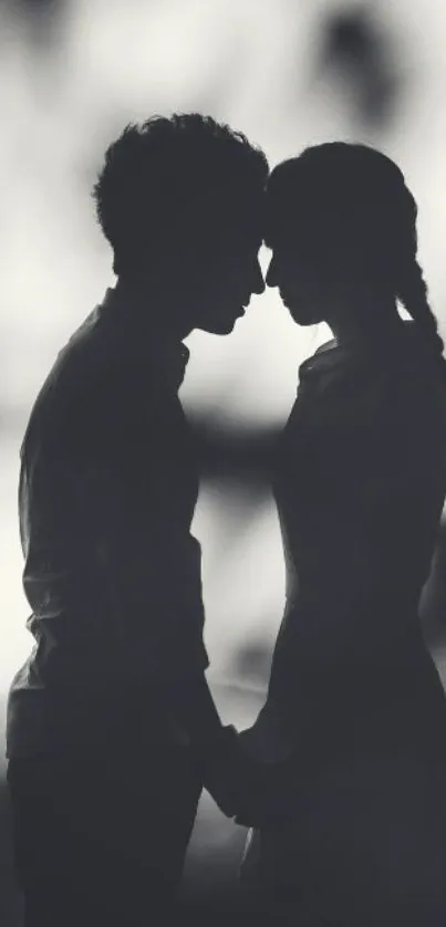 Black and white silhouette of a romantic couple holding hands.