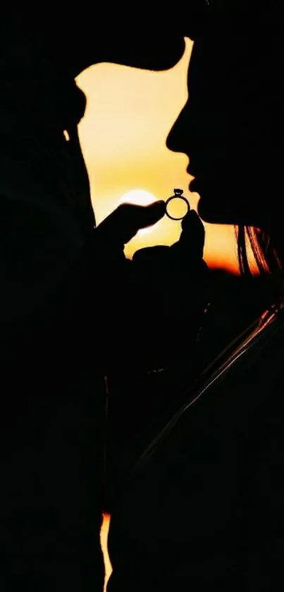 Silhouette of couple with ring against a sunset backdrop, symbolizing romance.