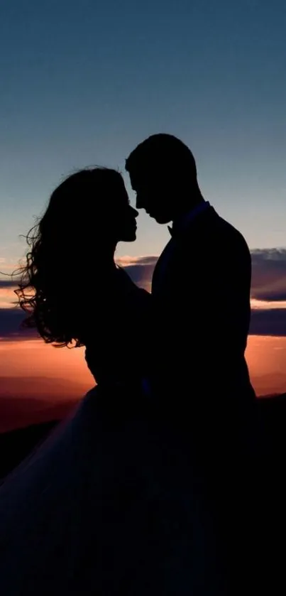 Silhouette of couple embracing at sunset with vibrant, colorful sky.