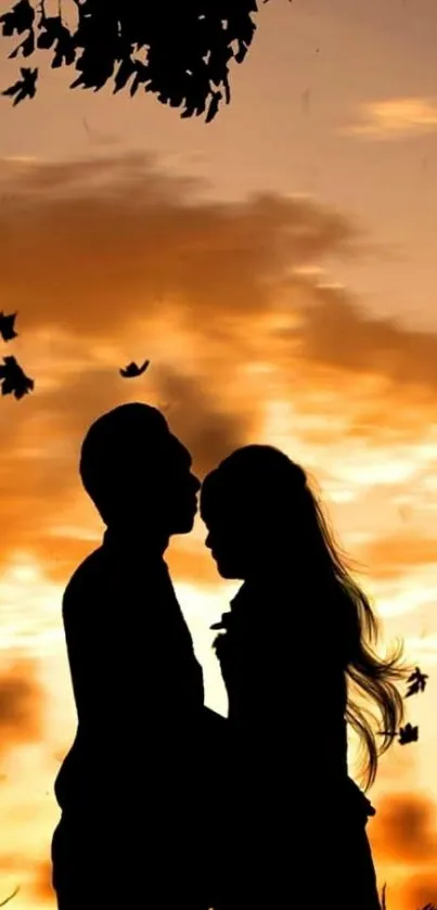 Romantic couple silhouette at sunset with autumn leaves.