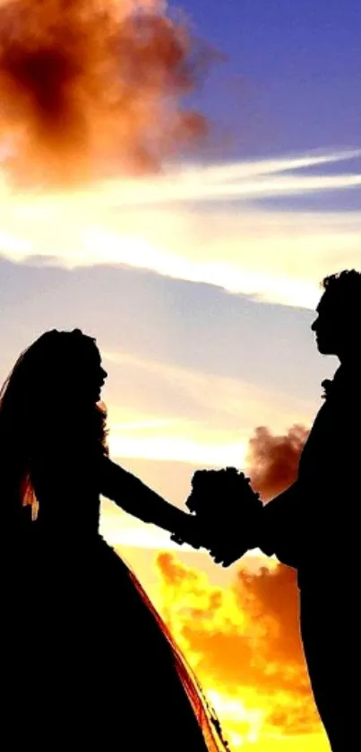 Silhouette of couple holding hands at sunset.