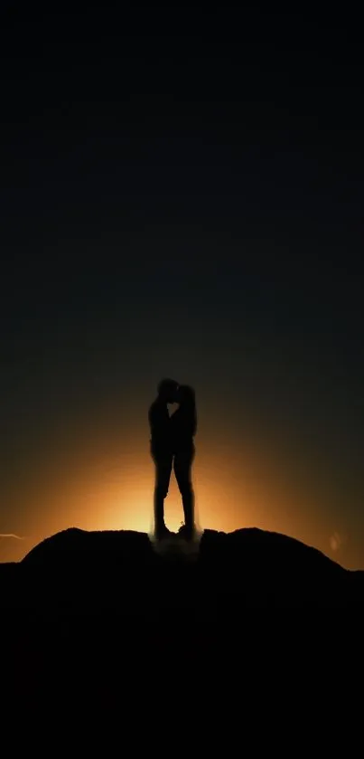 Romantic silhouette of a couple at sunset on a hilltop.