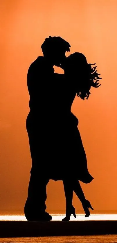 Silhouette of a couple kissing at sunset.