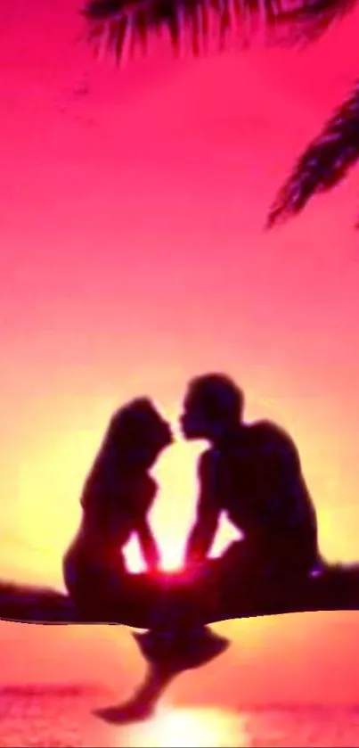 Silhouette of a couple kissing against a vibrant pink sunset.