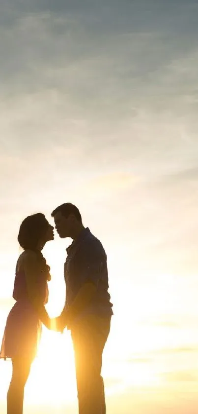 Romantic couple silhouette at sunset with soft golden hues in the background.