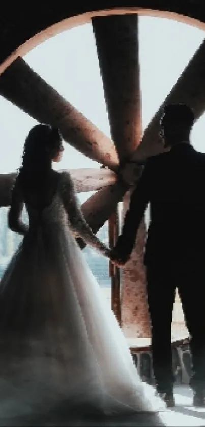 Silhouette of couple holding hands with industrial fan.