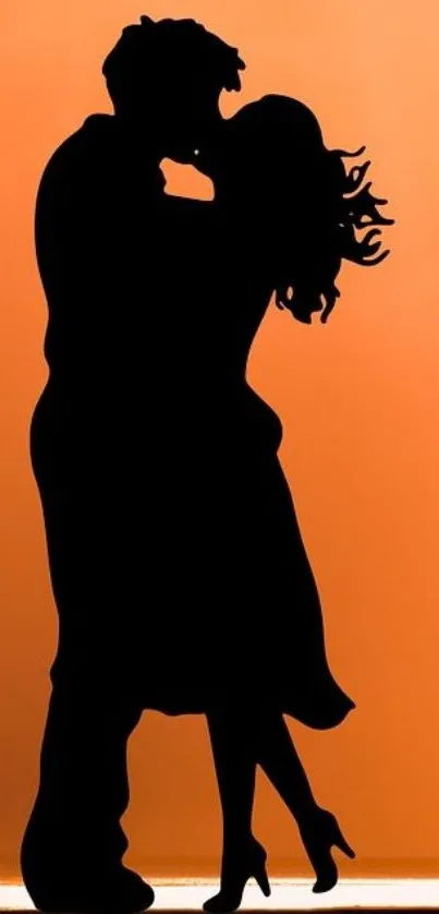 Silhouette of a couple embracing with orange background.