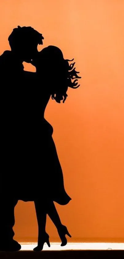 Romantic couple silhouette on orange background.