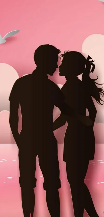 Silhouetted couple against pink sunset sky.