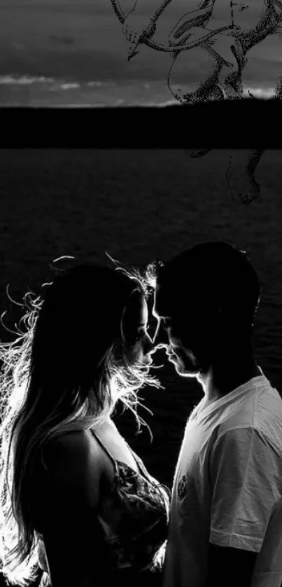 Black and white silhouette of a romantic couple by the ocean.