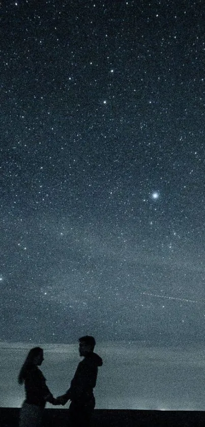 Silhouette couple under a starry night sky.