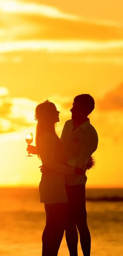 Romantic sunset beach with a couple silhouetted by the ocean.