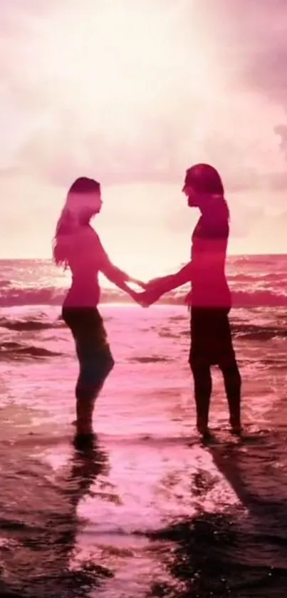 Silhouette of a couple holding hands at a pink sunset beach.