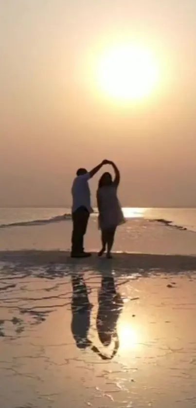 Couple dancing in silhouette against a stunning sunset on the beach.