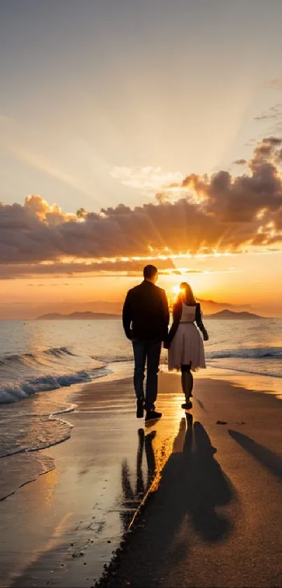 Couple walks on beach at sunset with golden sky.