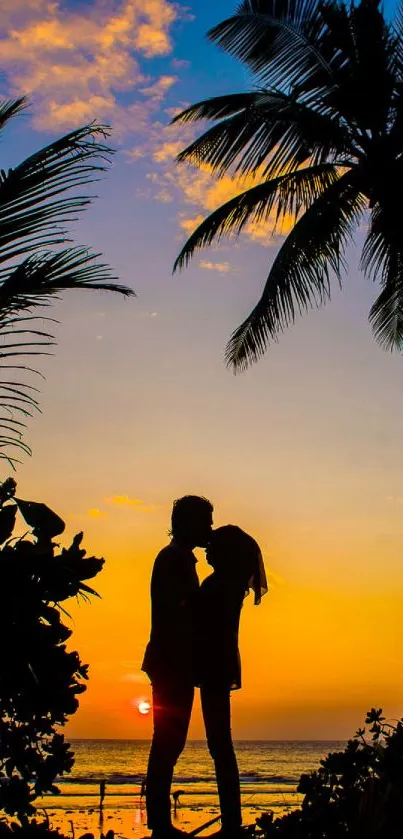 Couple silhouetted against a sunset with palm trees in the background on the beach.