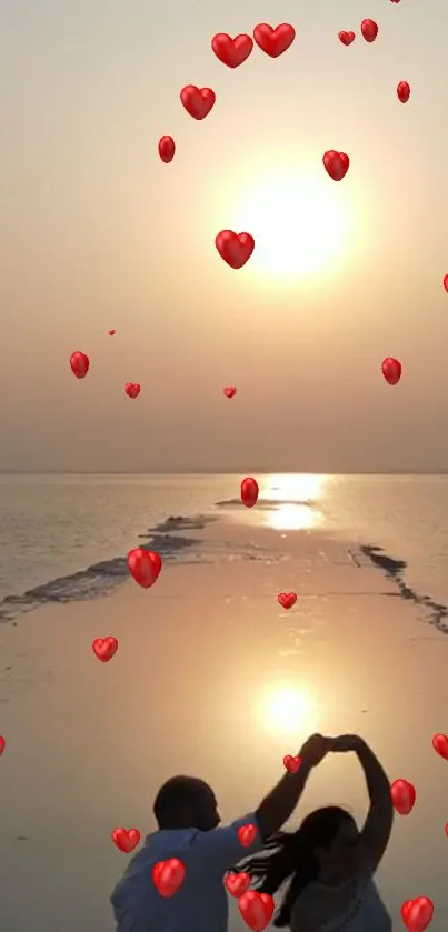 Couple dancing on a beach at sunset with floating red heart balloons.