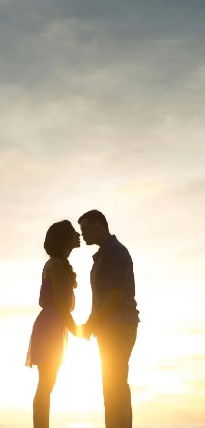 Silhouette of a couple against a golden sunset sky.