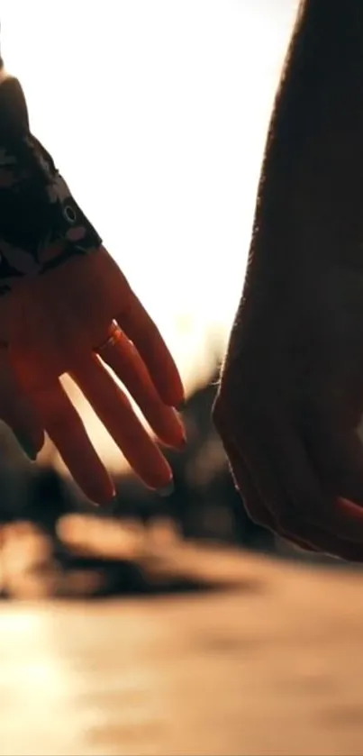 Hands touching at sunset, evoking romance.