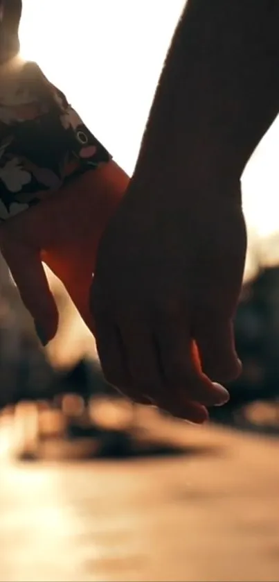 Couple holding hands at sunset, creating a romantic silhouette.