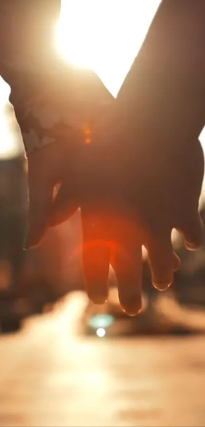 Couple holding hands at sunset in a glowing, romantic backdrop.