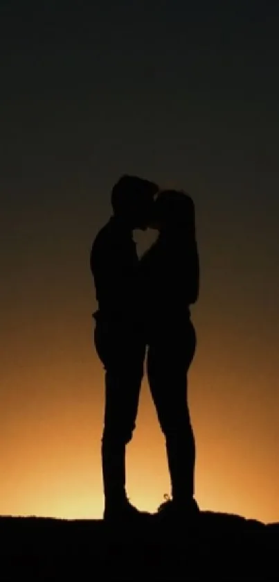 Silhouette of a couple embracing with a sunset background.