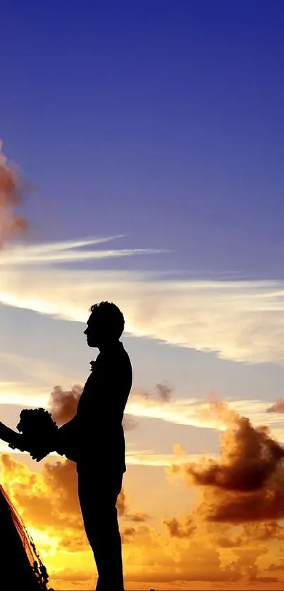 Silhouette couple holding hands at sunset under a vibrant sky.