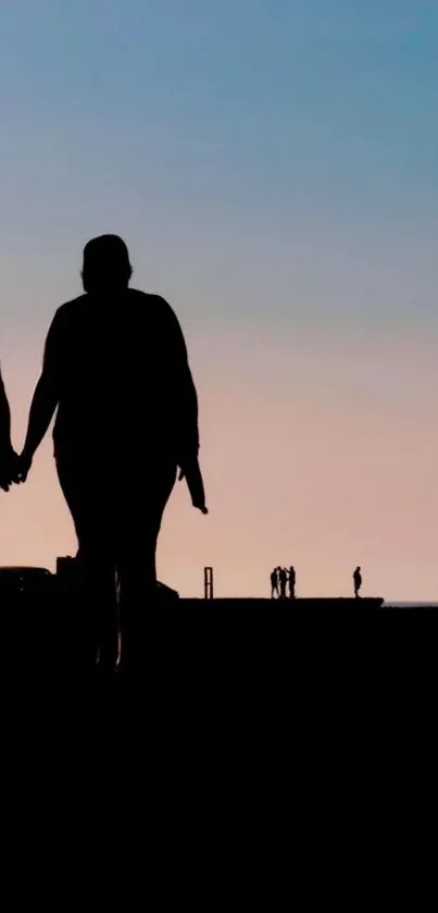 Romantic silhouette of a couple holding hands against a serene sunset sky.