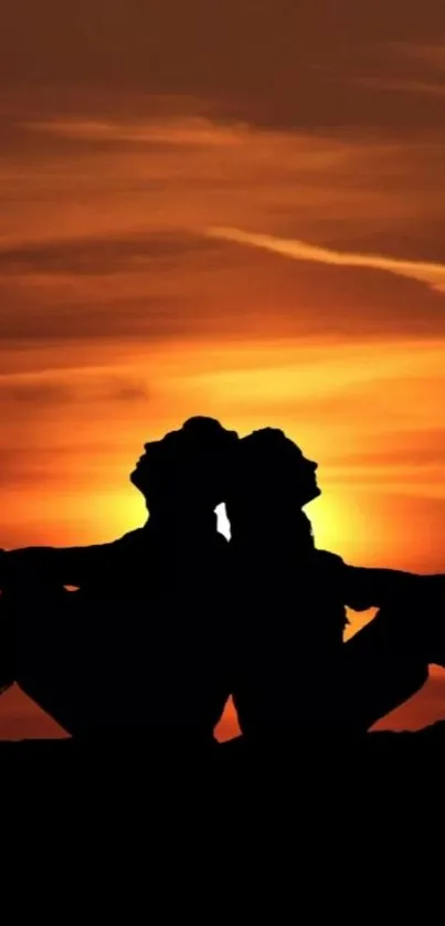 Silhouetted couple against orange sunset backdrop.