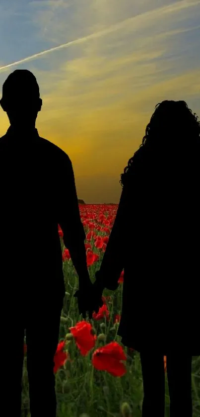 Silhouette of a couple holding hands in a poppy field at sunset.