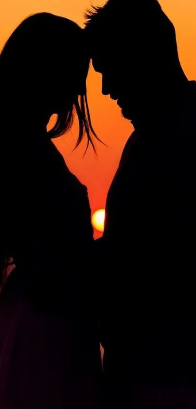 Silhouette of a couple during a vibrant orange sunset.