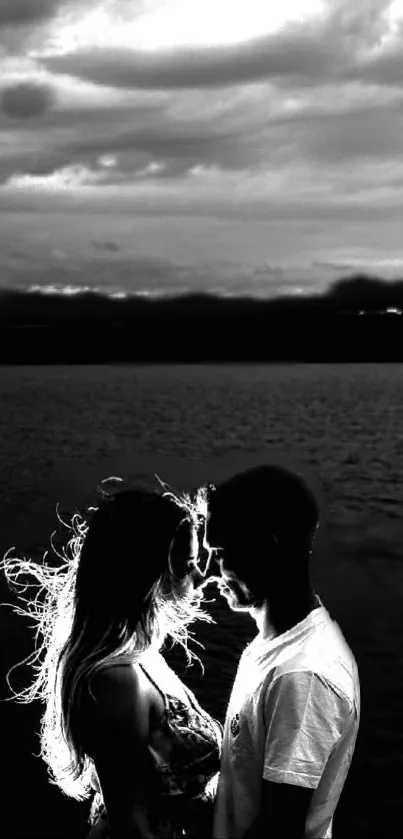 Romantic silhouette of couple by lake during sunset.