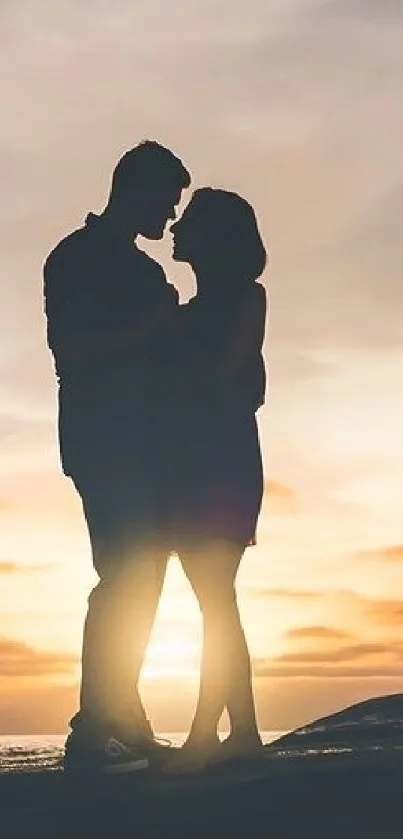 Silhouette of a couple embracing at sunset on a tranquil beach.