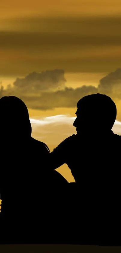 Silhouette of a couple in a romantic sunset setting with golden clouds.