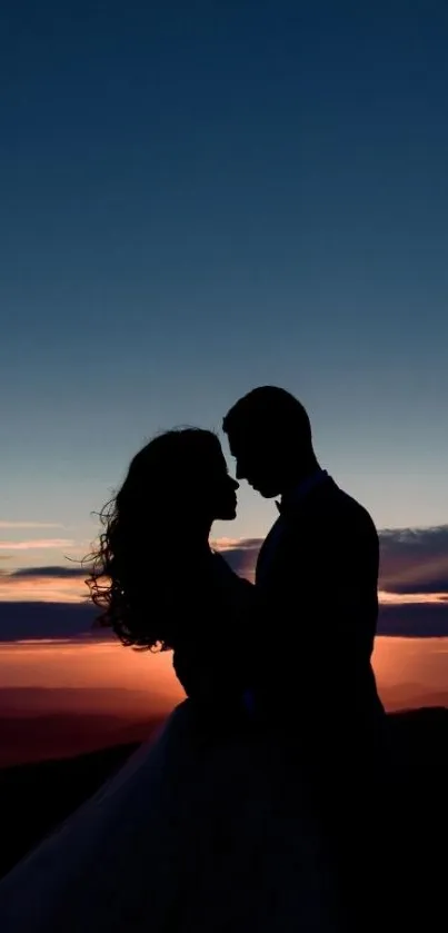 Couple silhouetted against a vibrant sunset sky.