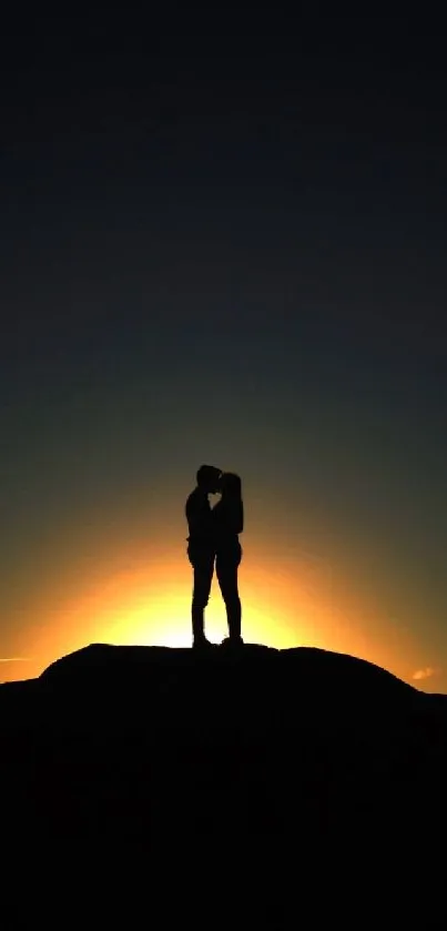 A romantic silhouette of a couple against a sunset backdrop on a dark horizon.