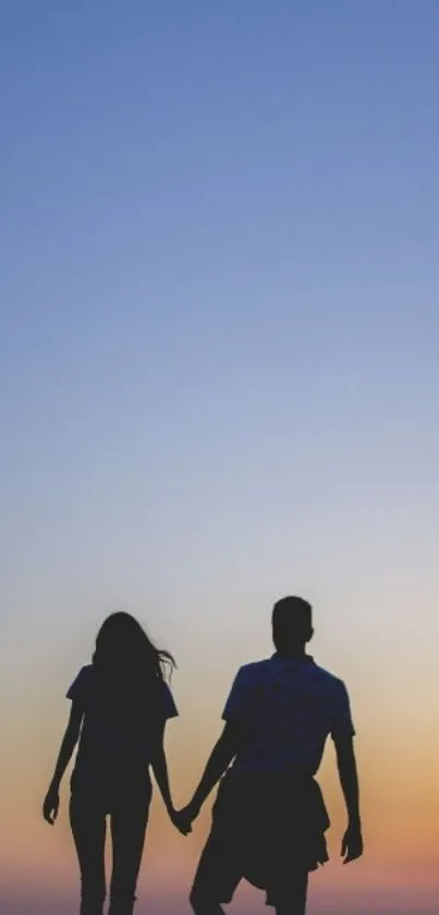 Silhouette of a couple holding hands against a colorful sunset sky.