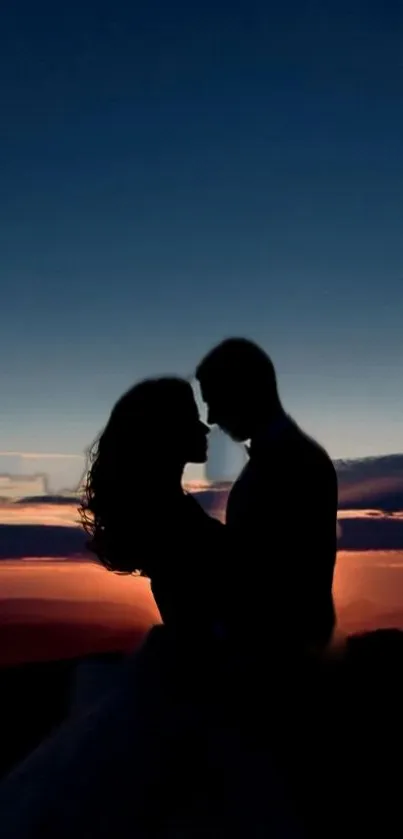 Silhouette of a couple against a vibrant sunset sky.