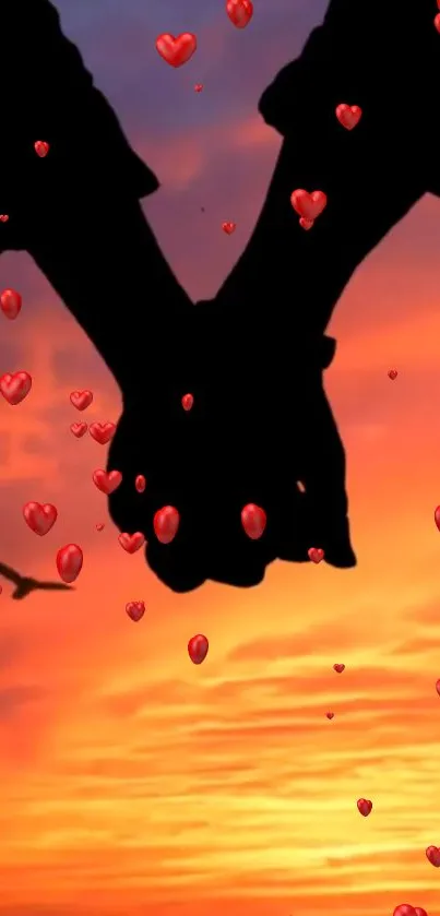 Silhouette of couple holding hands at sunset with hearts.