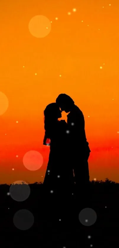 Silhouette of a couple kissing at sunset with an orange sky.