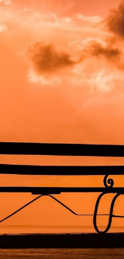 Romantic silhouette of a couple embracing at sunset with an orange sky.