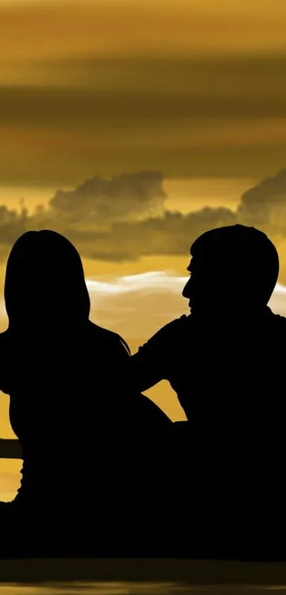 Silhouette of a couple against a golden sunset backdrop.